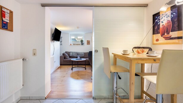 Un salon moderne comprenant un canapé, une table basse et un coin repas avec une table et des chaises.