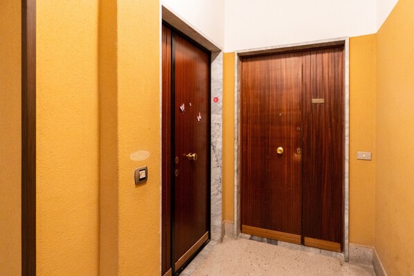 Un pasillo con dos puertas de madera, una con pomo de latón y la otra con picaporte redondo.