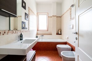Un baño con bañera, inodoro y bidé.