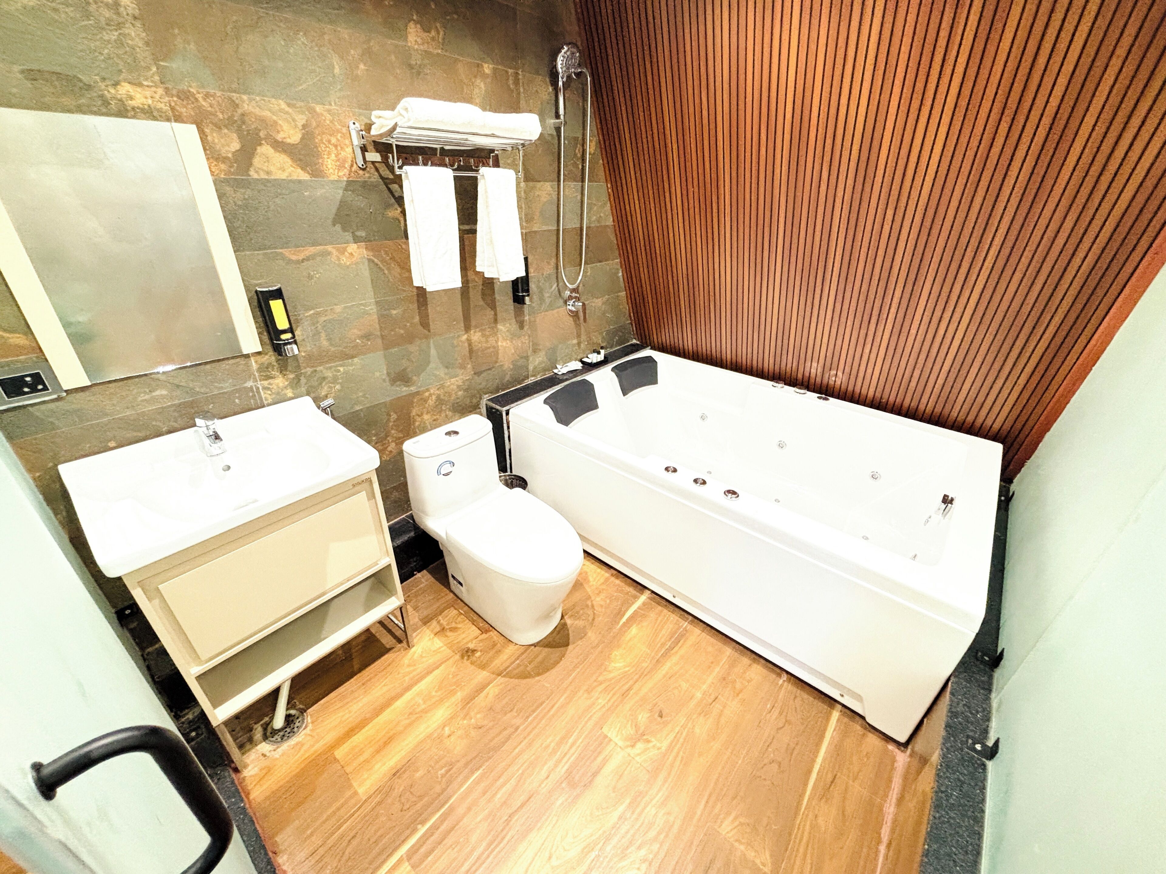 A modern bathroom with a bathtub, toilet, and sink.