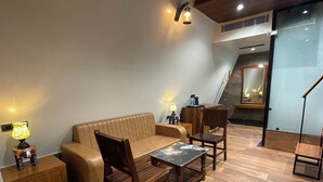 Ein modernes Wohnzimmer mit einer Couch, Holzstühlen, einem Couchtisch und einer Lampe.