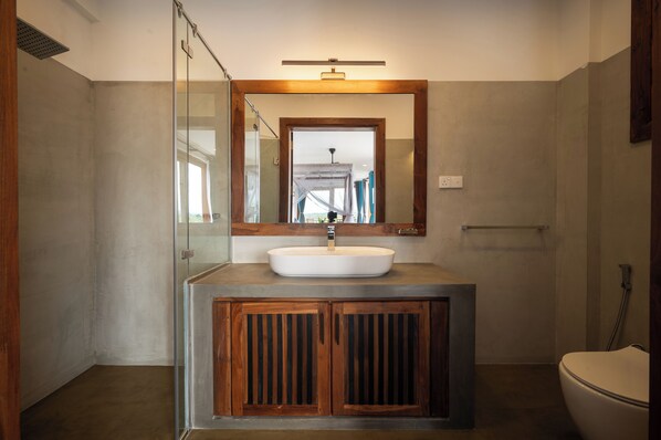 A bathroom with a large mirror, a sink, and a toilet. - Tangalle Villa (Tangalle)