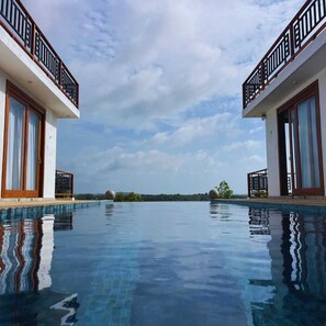 A pool with a clear view of the sky and distant landscape. - Tangalle Villa (Tangalle)