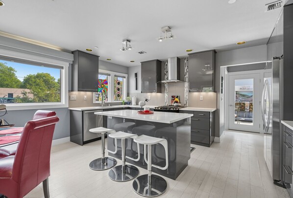 Fridge, oven, stovetop, dishwasher - Top-level duplex featuring a sleek open concept kitchen with stainless appliances, cozy fireplace, stylish furnishings, and in-unit washer/dryer. Designed for basking in the sun under skylights in thoughtful details throughout. (Vancouver)