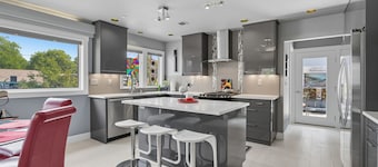Top-level duplex featuring a sleek open concept kitchen with stainless appliances, cozy fireplace, stylish furnishings, and in-unit washer/dryer. Designed for basking in the sun under skylights in thoughtful details throughout.