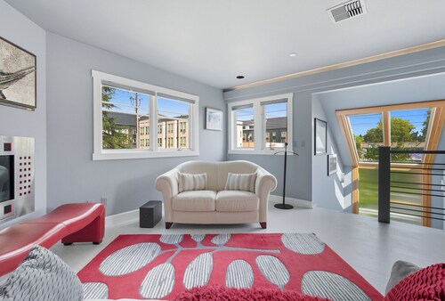 Top-level duplex featuring a sleek open concept kitchen with stainless appliances, cozy fireplace, stylish furnishings, and in-unit washer/dryer. Designed for basking in the sun under skylights in thoughtful details throughout.
