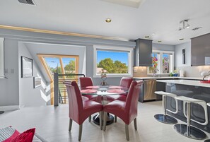 Interior - Top-level duplex featuring a sleek open concept kitchen with stainless appliances, cozy fireplace, stylish furnishings, and in-unit washer/dryer. Designed for basking in the sun under skylights in thoughtful details throughout. (Vancouver)