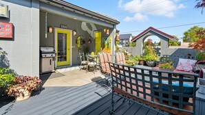 A patio area with outdoor seating, a grill, and potted plants. - Top-level duplex featuring a sleek open concept kitchen with stainless appliances, cozy fireplace, stylish furnishings, and in-unit washer/dryer. Designed for basking in the sun under skylights in thoughtful details throughout. (Vancouver)