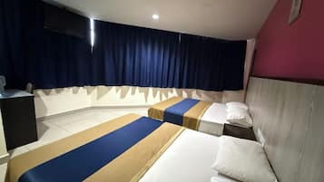 A hotel room with two beds, a desk, a TV, and a curtain.