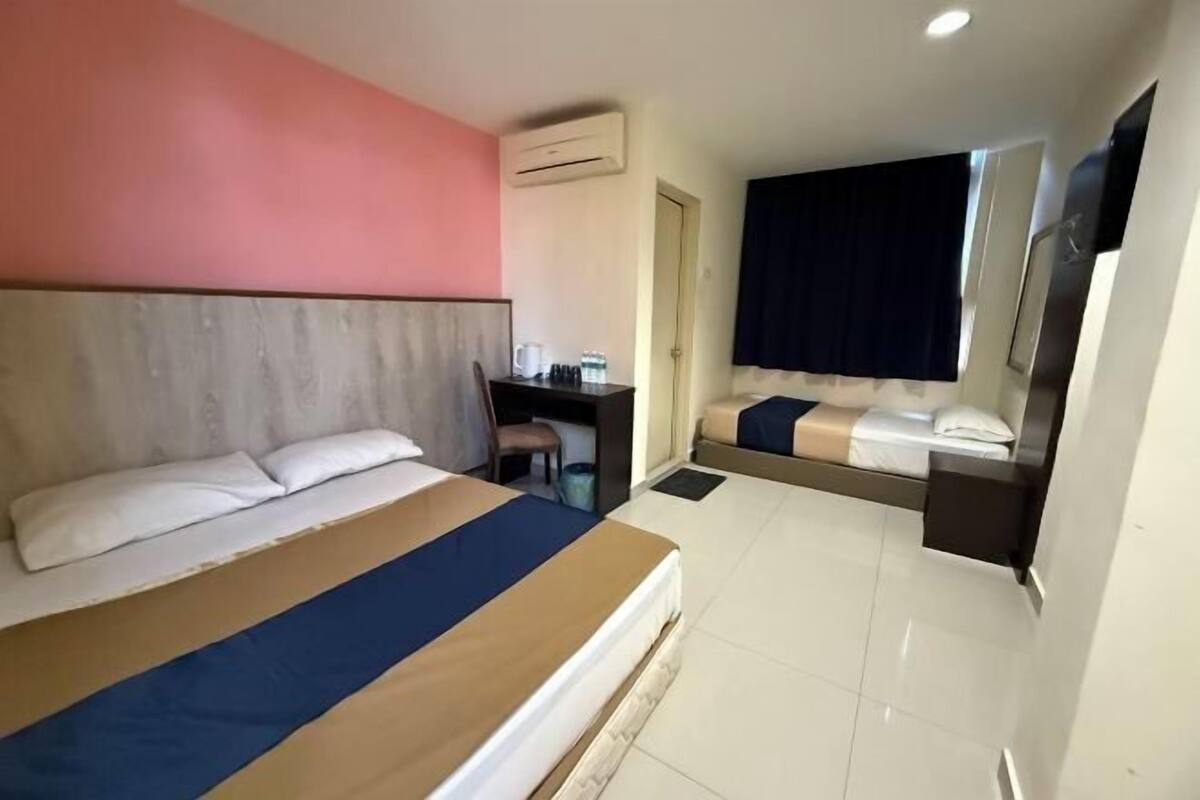 Una camera d'albergo con un letto grande, una scrivania, una sedia e un tavolino.