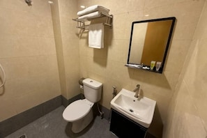 Ein kleines Badezimmer mit Toilette, Waschbecken und Spiegel.
