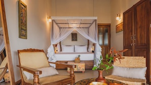 A room with a bed, two wooden chairs, a round table with a vase and book, and a wooden cabinet. - Villa Monkey House (Tangalle)