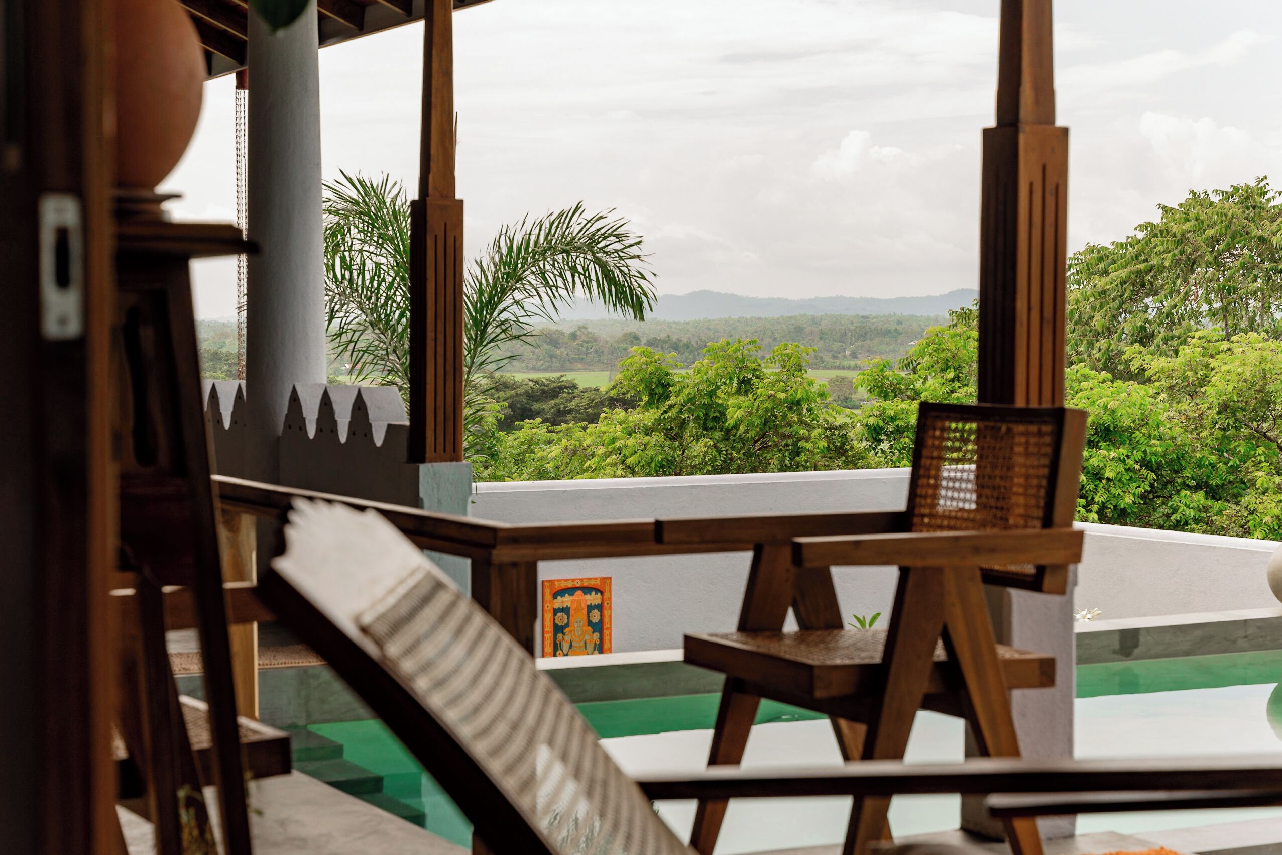 A wooden deck with a view of lush greenery and hills.