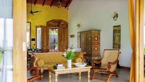 A traditional living room with a sofa, armchairs, a cabinet, and a ceiling fan. - Villa Monkey House (Tangalle)