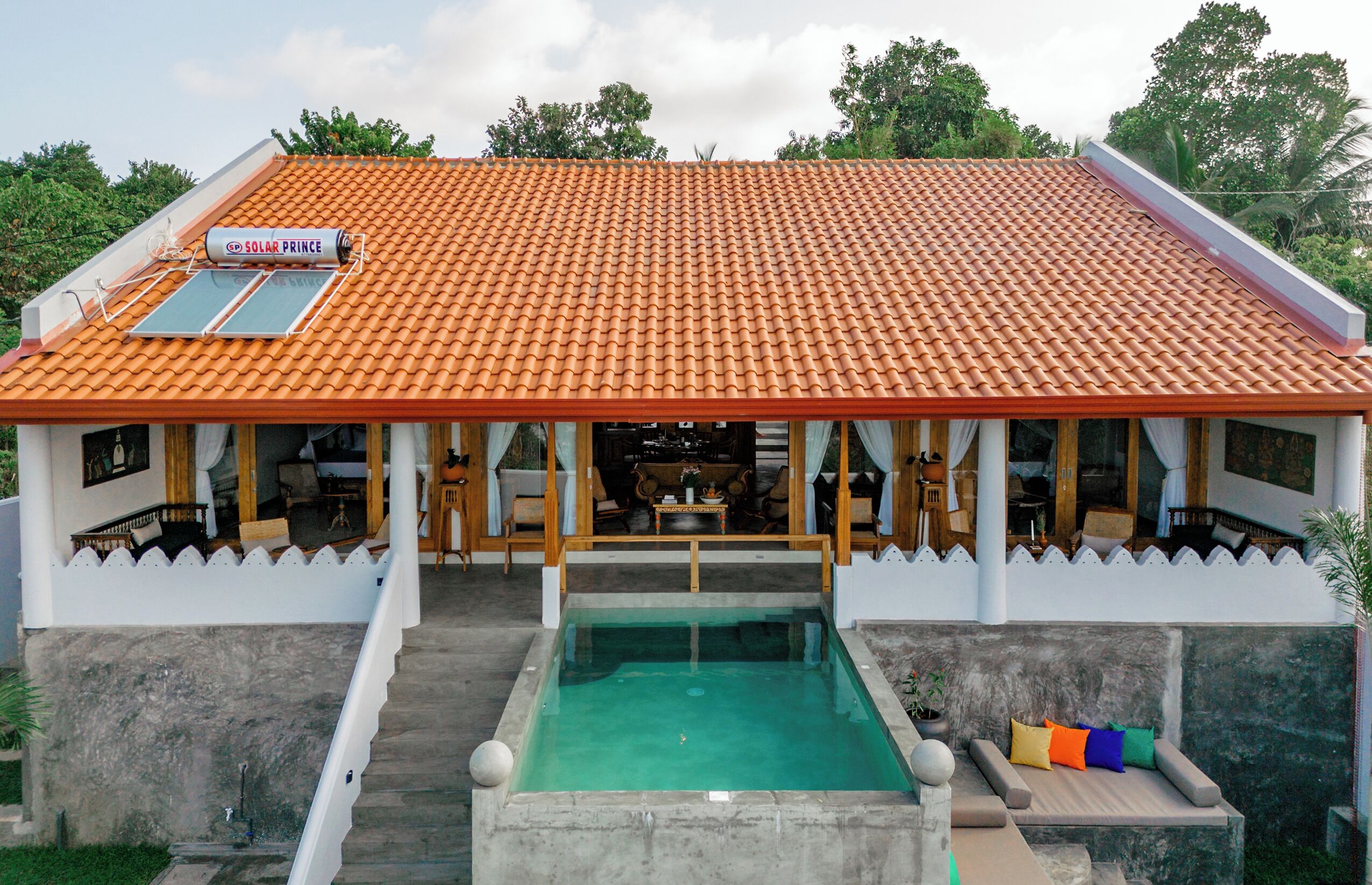 A building with a tiled roof, a swimming pool, and a sign reading "SOLAR PRINCE".