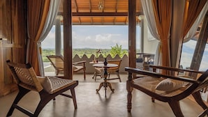 A cozy outdoor seating area with wicker chairs and a table, overlooking a scenic landscape. - Villa Monkey House (Tangalle)