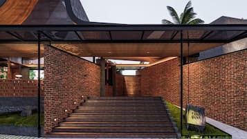 A modern building with a brick facade, a staircase leading to an entrance, and a covered area with a roof.