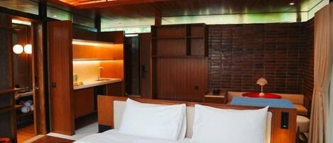 Una habitación de hotel con cama, mesitas de noche, un escritorio y una zona de estar.