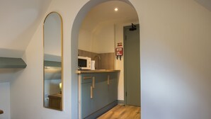 A modern kitchen with a microwave, cabinets, and a fire blanket sign.
