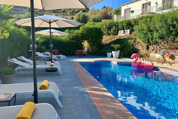 Una piscina al aire libre, sombrillas, tumbonas