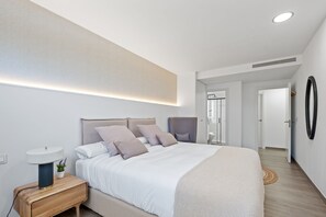 Un dormitorio moderno con una cama grande, una mesita de noche y un vestidor.