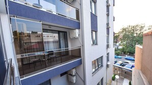 A multi-story residential building with balconies, air conditioning units, and a view of parked cars and trees. - Bucharest Old Town Apartments (Bucharest)