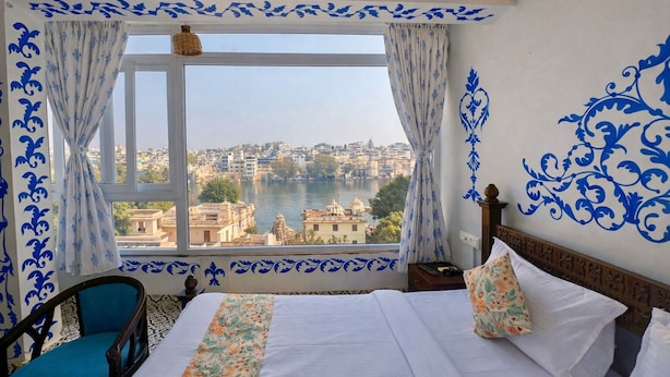 Ein Hotelzimmer mit großem Fenster und Blick auf Stadt und Fluss.