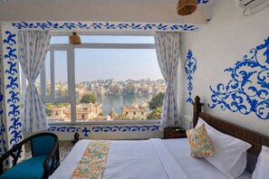 Ein Hotelzimmer mit großem Fenster und Blick auf Stadt und Fluss.