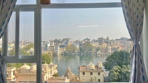 Blick aus einem Fenster auf einen Fluss und Gebäude, darunter ein Tempel.