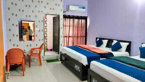 Une chambre d’hôtel avec deux lits, un miroir, une fenêtre avec des rideaux et une porte.