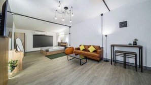 A modern living room with a sofa, coffee table, and a TV. - Oasis Suites - Pattaya - Huge Modern Apartments (Pattaya)