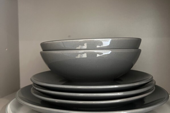 A stack of gray bowls on a white surface.