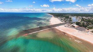 An aerial view of a coastal area with a beach, a pier, and a river. - Harbor Views, Hot Tub, Walk to Beach, Dog Friendly (South Haven)