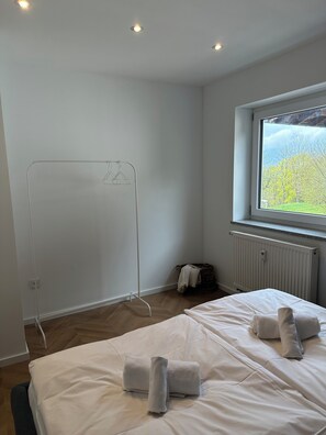 A hotel room with a bed, a radiator, a window with a view, and a clothes drying rack. - Schönblick B7 House · Modern home with a balcony next to the chairlift (Schöfweg)