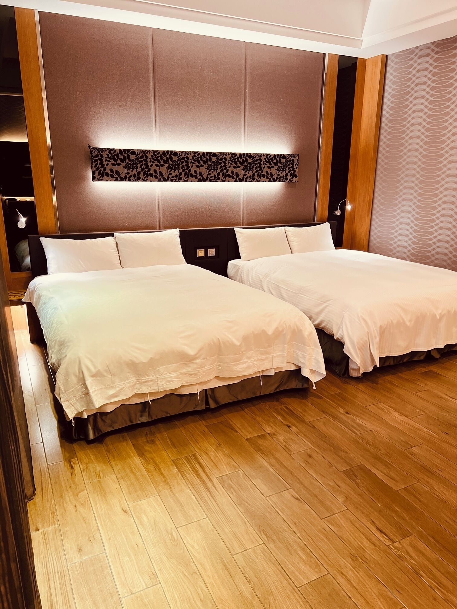 A double bed with a headboard, a bedside table, and a wall-mounted light fixture.