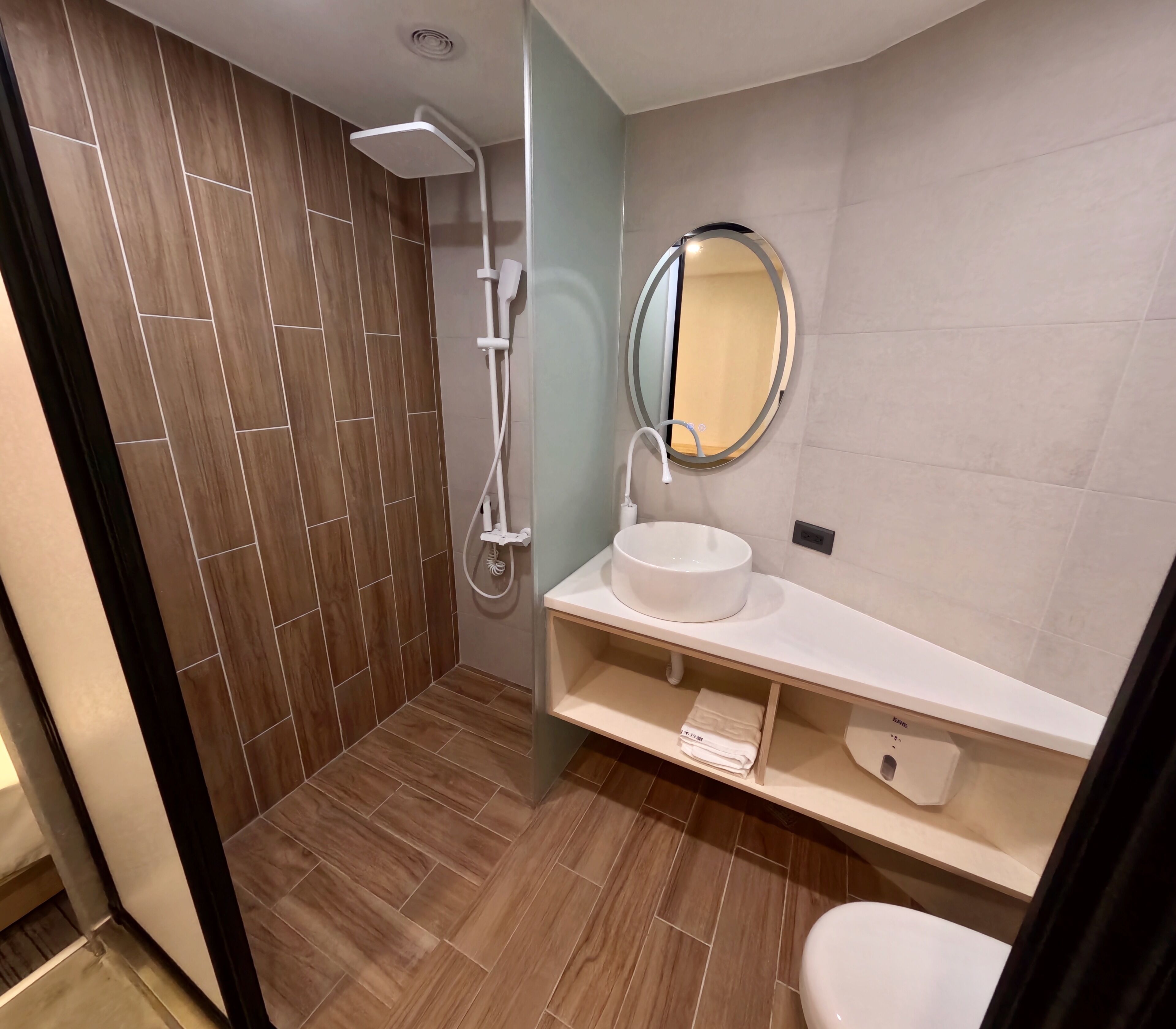 A modern bathroom with a shower, a sink with a mirror, and a toilet.