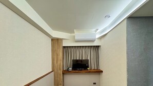 A narrow hallway with a wooden bench, a flat-screen TV, and an air conditioning unit on the ceiling. - Zuum Inn (Taipei)
