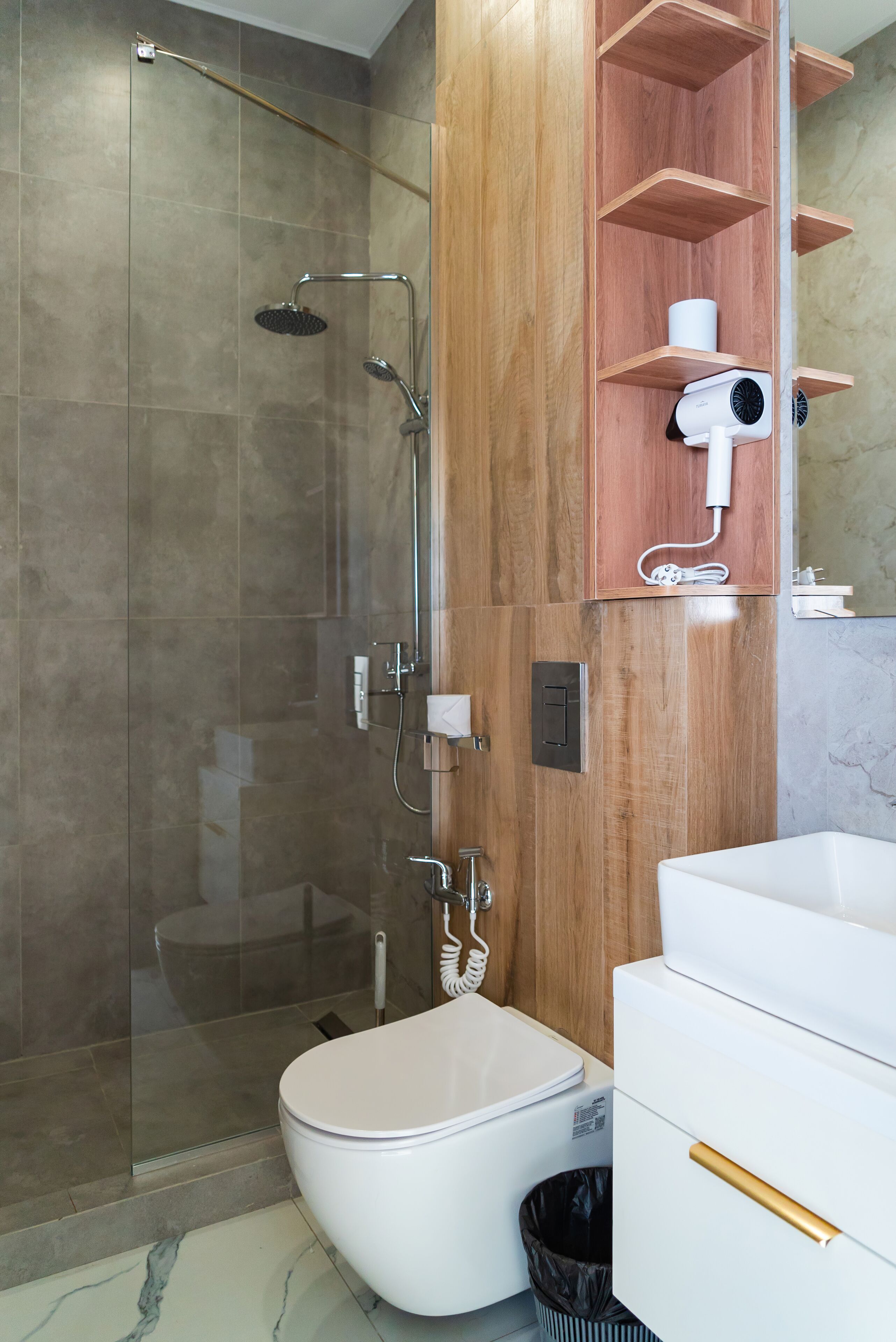 A modern bathroom with a glass-enclosed shower, a toilet, and a vanity with a mirror and storage.