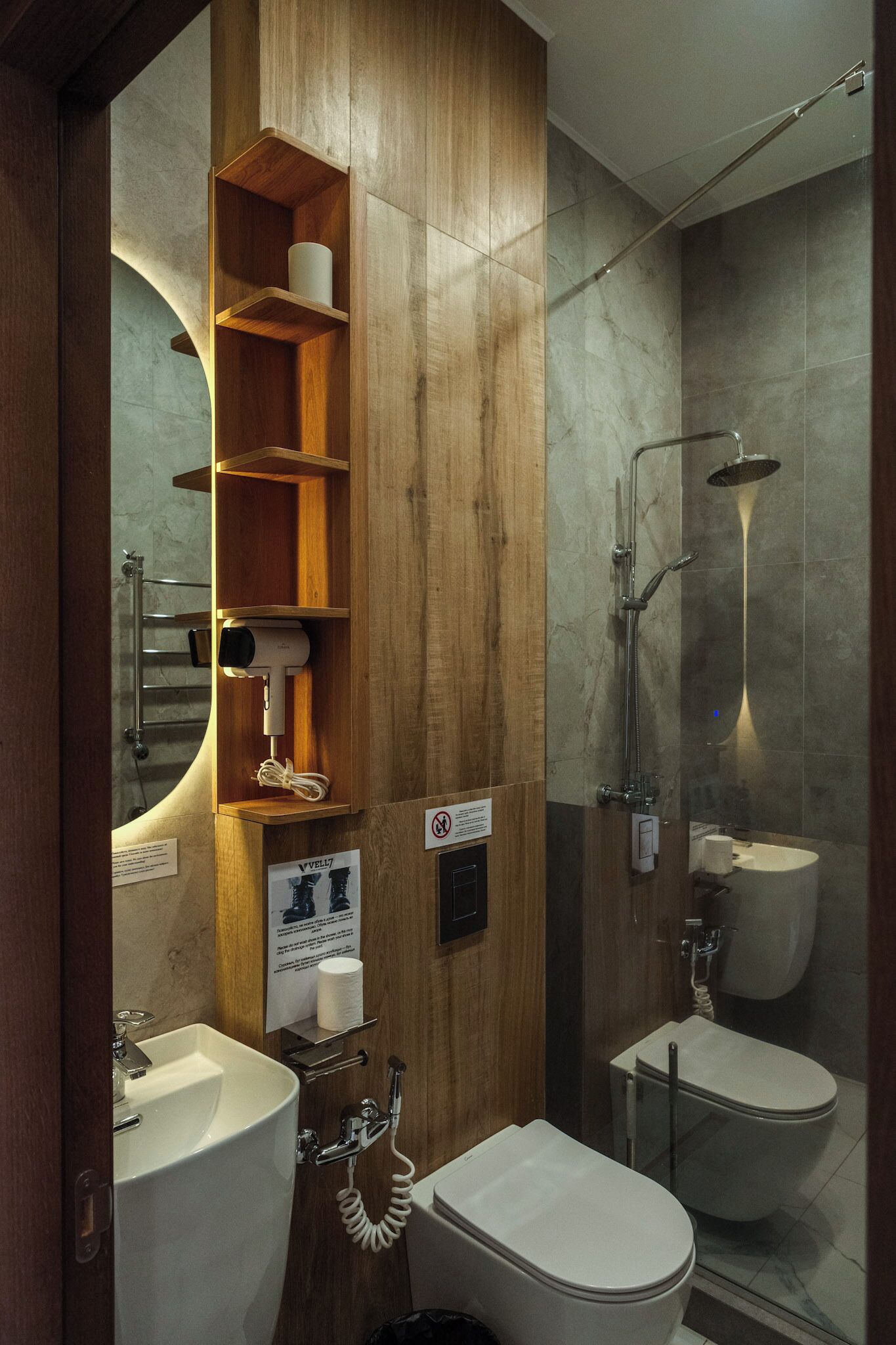 A modern bathroom with a wooden vanity, a glass-enclosed shower, and a toilet.