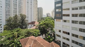 Un edificio residencial de gran altura con varios pisos, ventanas amplias y una combinación de balcones y terrazas.
