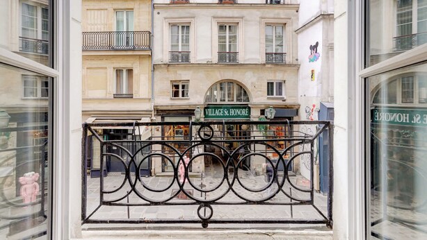 Une vue d’un bâtiment sur lequel on peut lire l’inscription « VILLAGE St. HONORÉ », avec une grille en fer forgé décorative au premier plan.