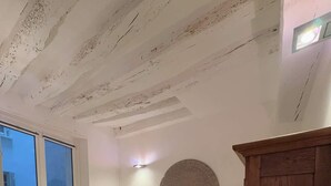 Une chambre à coucher avec un lit, des lampes de chevet, un élément de décoration circulaire fixé au mur, une armoire en bois et une fenêtre.