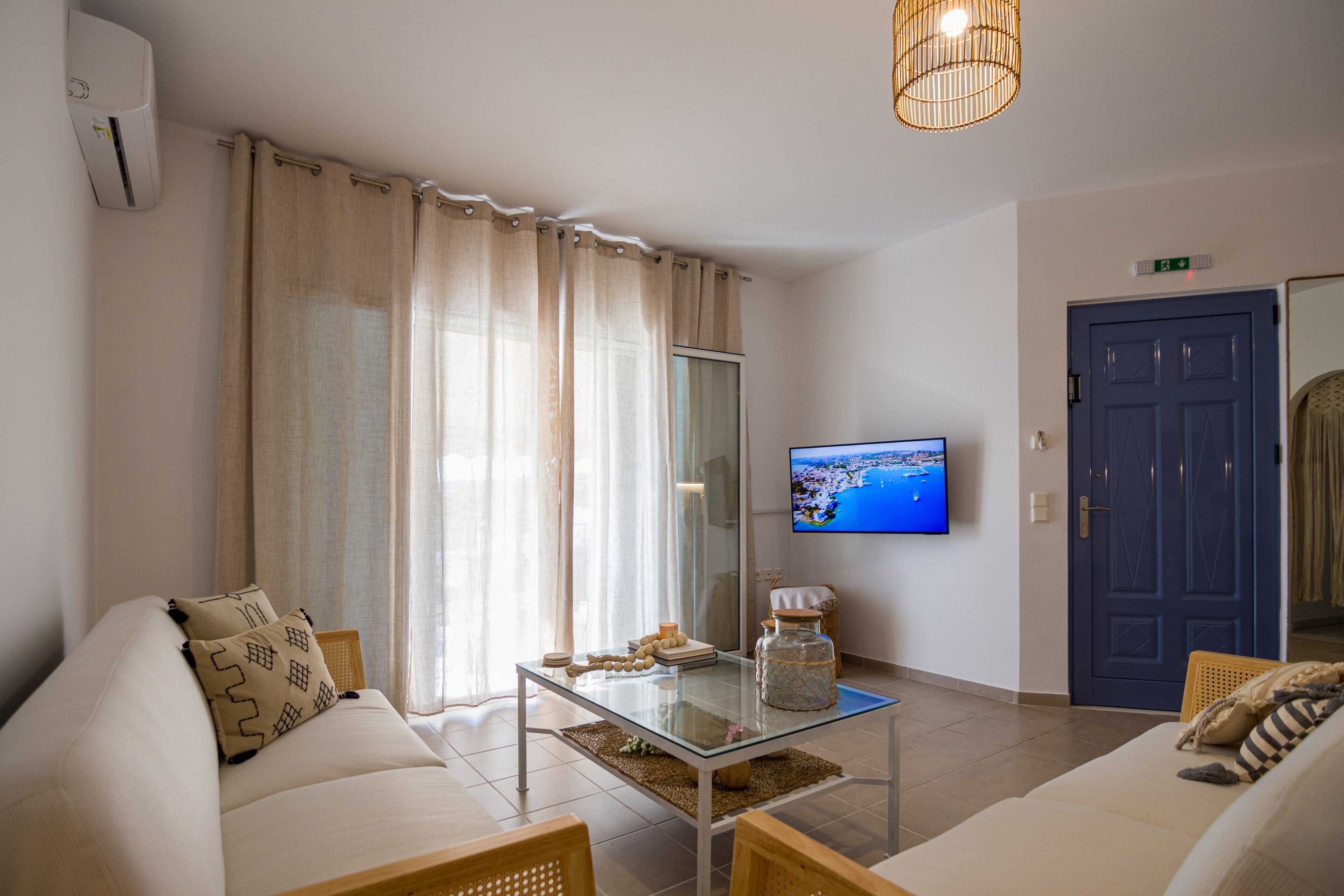 A modern living room with a sofa, a coffee table, and a television mounted on the wall.
