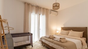 A bedroom with a bed, a hanging laundry rack, and a window with curtains.