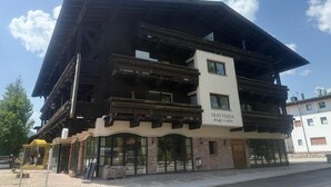 Un edificio con techo inclinado, varios balcones y un letrero que dice 'TRATTORIA Luigi & Lois'.