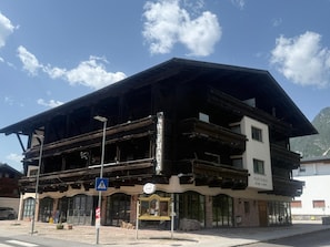 A two-story building with a wooden facade, a balcony, and a sign that reads 'Kaufhaus.'