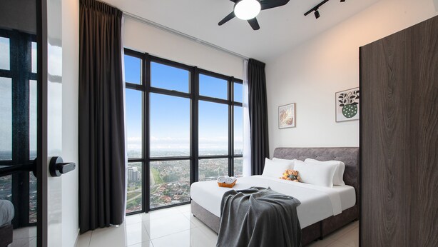 A modern hotel room with a large bed, a view of the city, and a ceiling fan. - Space Residency by A----Walk 100m to KSL (Johor Bahru)