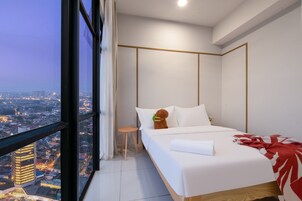 A modern hotel room with a large window, a bed, a small stool, and a view of the cityscape.