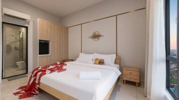 Una camera d'hotel moderna con un letto grande, un comodino, un armadio e un angolo doccia.