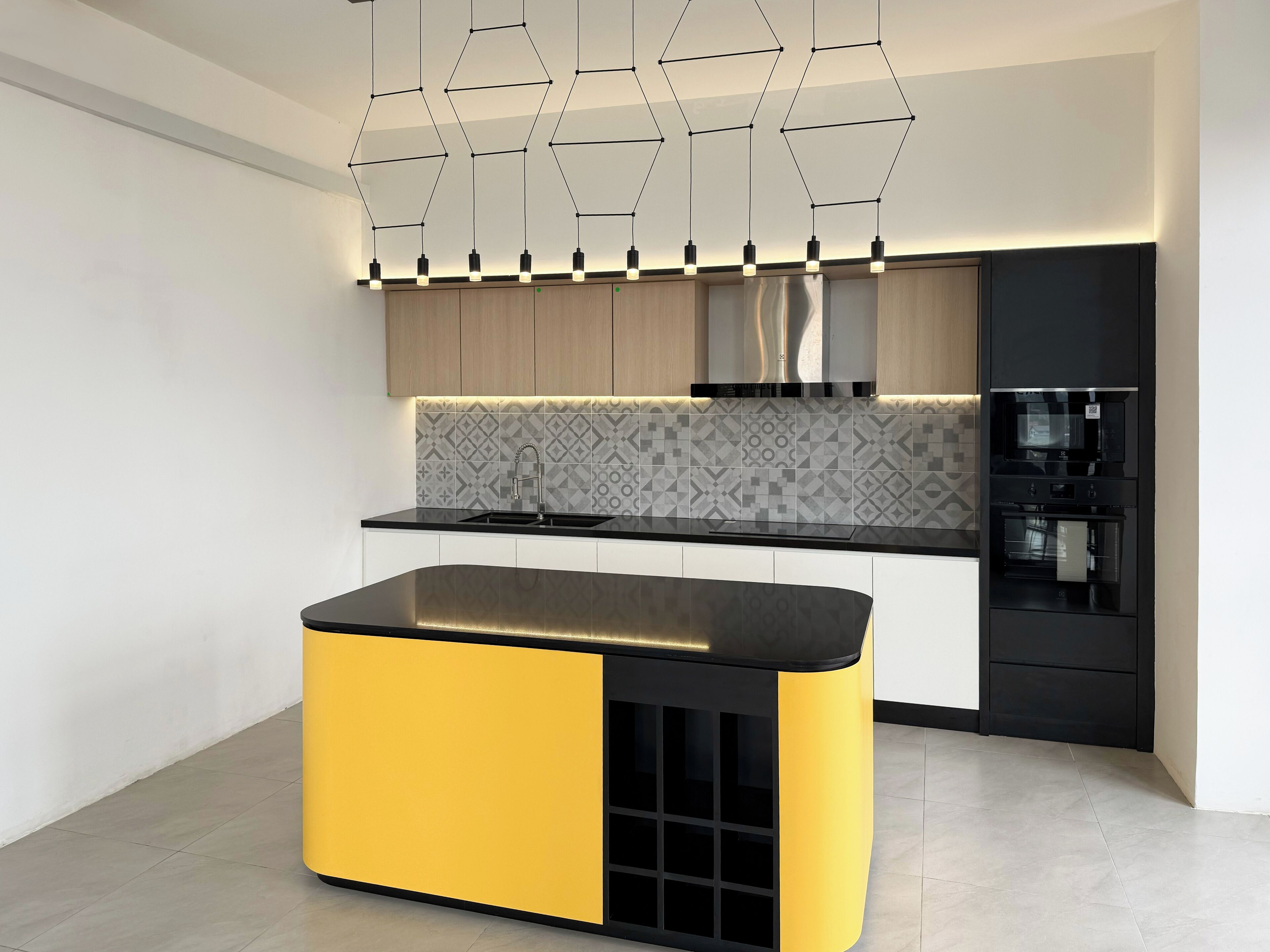 Una cocina moderna con una isla central, horno empotrado y microondas.
